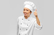© Syda Productions - cooking, gesture and people concept - happy smiling female chef in jacket showing thumbs up over grey background