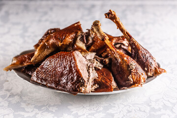 Portioned roast goose on a white plate - Close up