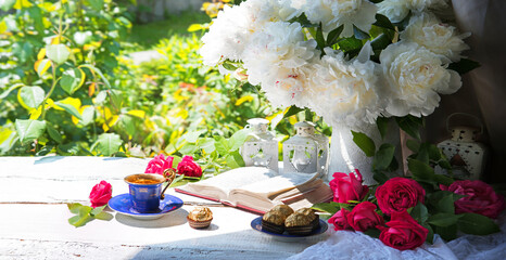 Wall Mural - Bible and a bouquet of peonies on a table in the garden