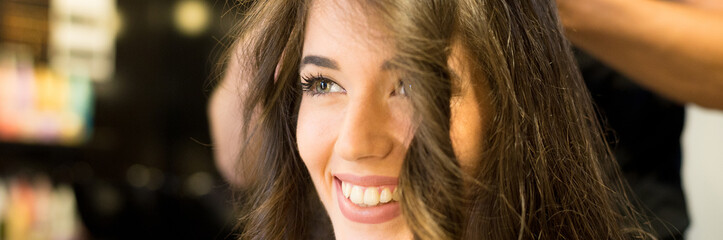 Young woman getting new hairstyle from hairdresser in the modern hair salon