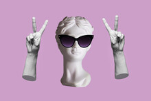 Antique Female Statue's Head In Black Sunglasses Showing A Peace Gesture With Hands Isolated On A Purple Color Background. Trendy Collage In Magazine Surreal Style. 3d Contemporary Art. Modern Design