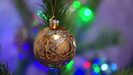 Wall Mural - Christmas tree decorated with golden glass ball on christmas spruce branch on background bokeh of flickering light bulbs garlands. Happy New Year festival mood. Positive emotion.