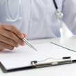 © Puwasit Inyavileart - Doctor uses a laptop computer to record patient information and write it on a document to prepare for diagnosis in the room of a modern hospital, Emergency assistance and health care concept.