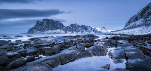 Sticker - Rocky beach in winter at night. Sea coast with stones