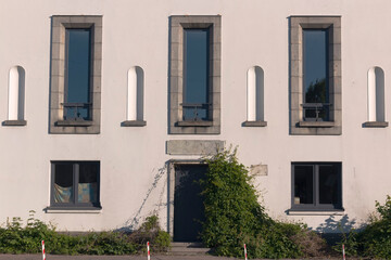 A modern building exterior with plants by summer day