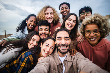 multiracial young group of happy people taking selfie portrait - millennial diverse friends laughing