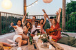 © Astarot - Excited friends take photos at the birthday summer rooftop party.