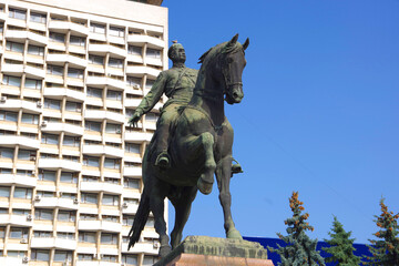 Wall Mural - Moldova. Kishinev. 27.08.22. View of the monument to Grigory Kotovsky against the backdrop of the Cosmos Hotel.