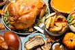 Traditional Thanksgiving day feast with delicious cooked turkey and other seasonal dishes served on grey table, flat lay