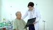 © DG PhotoStock - Asian elder adult having a consult with doctor about his disease, doctor explains the x-ray film to Asian senior adult.