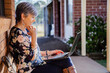 © Austockphoto - Smiling middle aged woman using her laptop to talk with grandkids