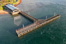 Aerial View Of A Restaurant At The Base Of A T Shaped Jetty On A Calm Bay