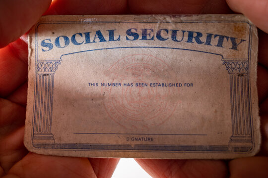 a u.s. social security card in the palm of a hand.