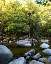 Man Standing On Rocks, Waterfall In Forest, Mossman Gorge. 