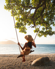 person relaxing on the beach, swinging on a makeshift swing, Fitzroy Island.