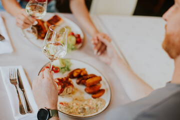 Wall Mural - Young couple having lunch with white wine in the restaurant