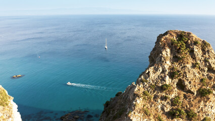 Wall Mural - Passing through the top of cliff on the calm summer sea in Italy