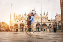 Happy Beautiful Couple Of Lovers Doing Romantic Trip In Venice, Italy - Tourists Visiting Historic Town Of Venice And St. Mark Square