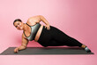 Full length of a beautiful fat woman practicing a side plank during a workout