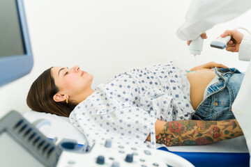 Wall Mural - Pregnant latin woman getting an ultrasound to check the health of the baby