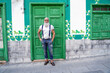 © neonshot - Full length photo of fashionable smiling senior man, positive emotions. Hipster guy wearing jeans and suspenders