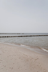 Wall Mural - Beach with white sand, neutral colour ocean water and blue sky. Natural background for summer vacation