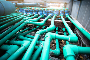 Wall Mural - Selective focus to many PPR green water pipe with blurry water meter and valve.