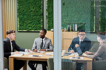 Wall Mural - Diverse group of business people in formalwear meeting in conference room with green eco design