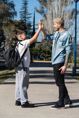 Wall Mural - Father and son in the street giving high five on a sunny day