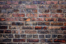 A Grungy Red Brick Wall With Old Vintage Bricks.