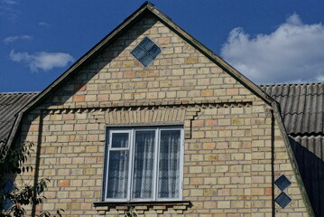 Sticker - one big brown brick attic of a private house with a window against the blue sky