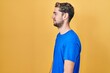 © Krakenimages.com - Hispanic man with beard standing over yellow background looking to side, relax profile pose with natural face and confident smile.