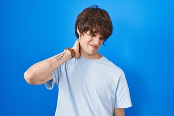 Sticker - Hispanic young man standing over blue background suffering of neck ache injury, touching neck with hand, muscular pain