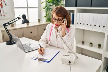 Sticker - Young caucasian woman wearing doctor uniform talking on the telephone at clinic