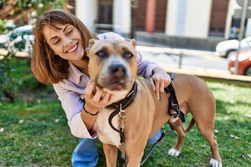 Young caucasian girl smiling happy standing with dog at the park.