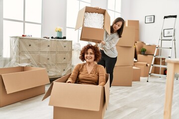 Canvas Print - Mature mother and down syndrome daughter moving to a new home, having fun inside box