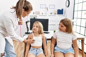 Mother and daughters doctor and patient auscultating heart having medical session at clinic