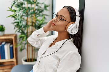 Canvas Print - Young african american woman smiling confident listening to music at waiting room