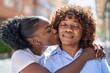 © Krakenimages.com - African american women mother and daughter hugging each other kissing at street