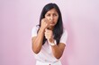 © Krakenimages.com - Young hispanic woman standing over pink background ready to fight with fist defense gesture, angry and upset face, afraid of problem
