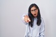© Krakenimages.com - Young hispanic woman wearing glasses pointing displeased and frustrated to the camera, angry and furious with you