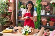 © Krakenimages.com - Young beautiful hispanic woman florist make photo to flower by smartphone at flower shop