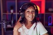 © Krakenimages.com - Young hispanic woman playing video games wearing headphones smiling happy pointing with hand and finger