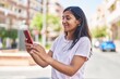 © Krakenimages.com - Young beautiful hispanic woman smiling confident using smartphone at street