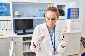 Poster - Young blonde woman wearing scientist uniform analysing blood at laboratory