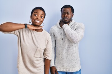 Sticker - Young african american couple standing over blue background together cutting throat with hand as knife, threaten aggression with furious violence