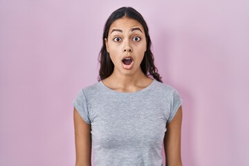 Sticker - Young brazilian woman wearing casual t shirt over pink background afraid and shocked with surprise expression, fear and excited face.