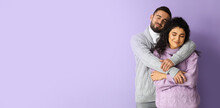 Happy Young Couple In Autumn Sweaters On Lilac Background With Space For Text