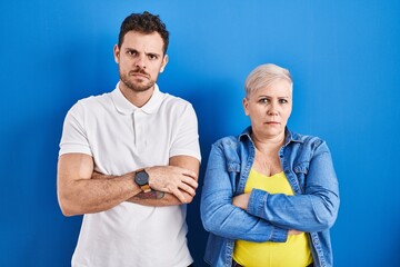 Sticker - Young brazilian mother and son standing over blue background skeptic and nervous, disapproving expression on face with crossed arms. negative person.