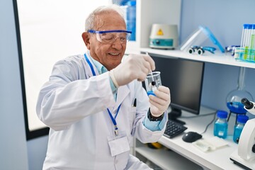 Poster - Senior man wearing scientist uniform mixing liquid at laboratory